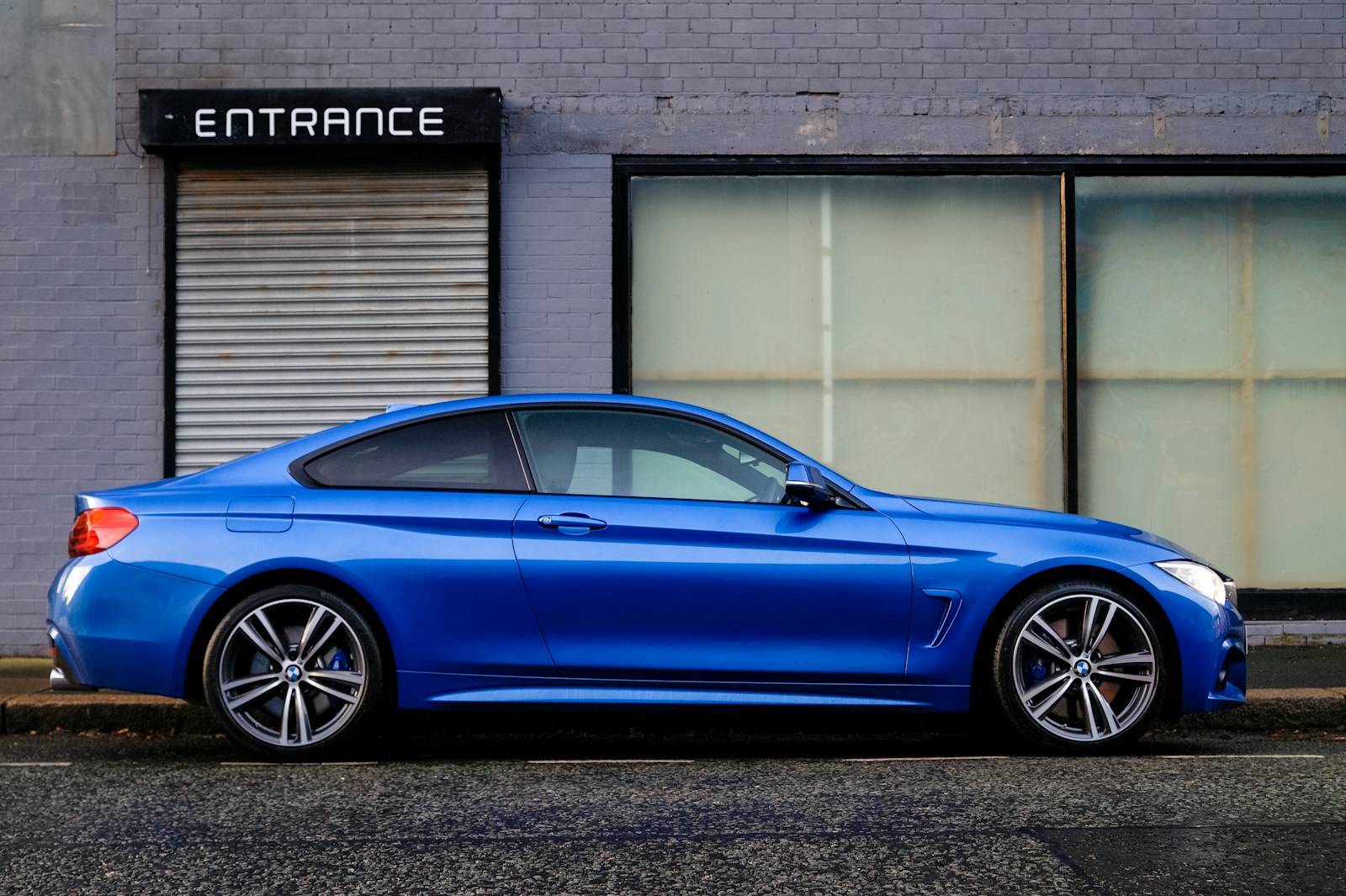 Photo by Grahame Jenkins blue coupe beside gray house